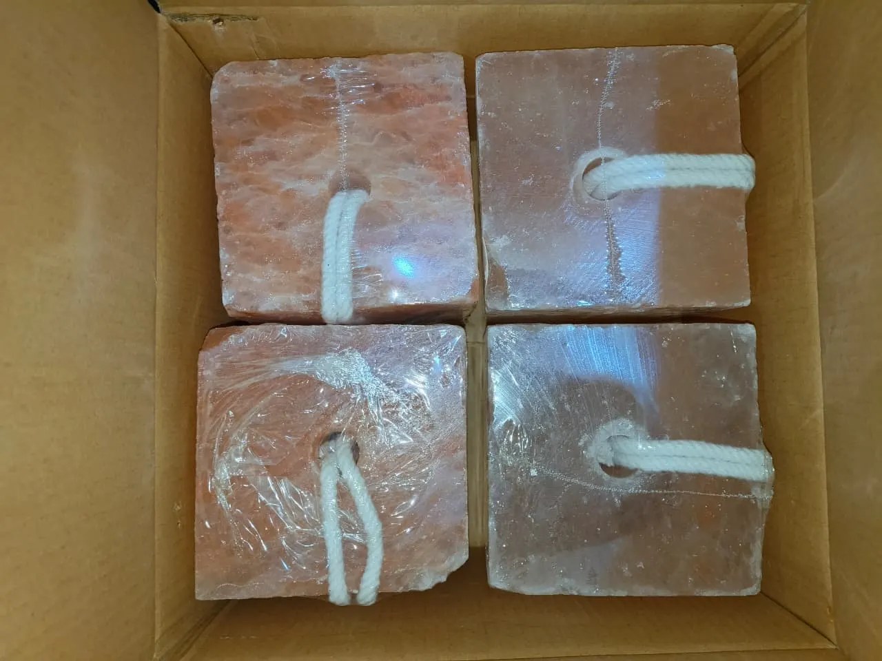 Four rope-bound Himalayan salt lick blocks packed in an export carton.